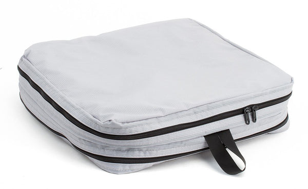 A filled and zipped closed Northwest Sky (light grey) Aether Large Aeronaut 30 Packing Cube all-fabric side up.